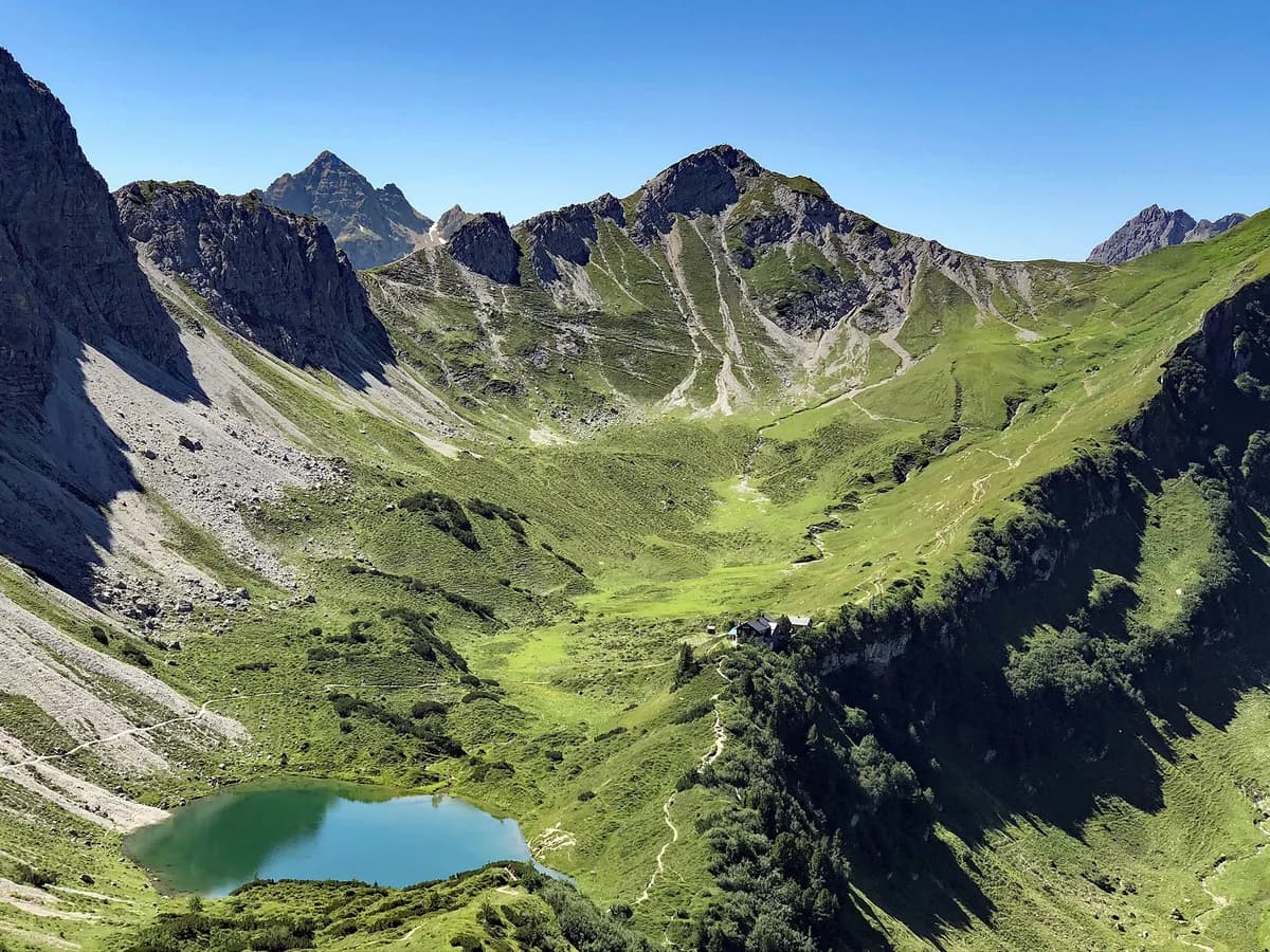Alpine lake and mountain hut on a clear summer day